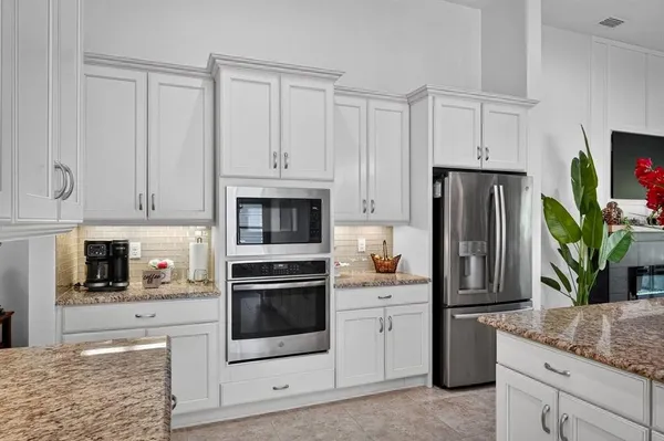 a kitchen with stainless steel appliances granite countertop a refrigerator sink and stove