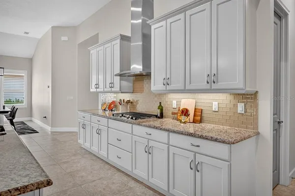 a kitchen with stainless steel appliances granite countertop a sink dishwasher and white cabinets with wooden floor