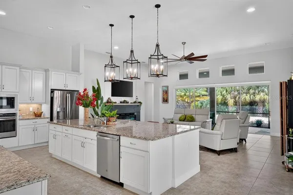 a kitchen with stainless steel appliances kitchen island granite countertop a refrigerator and a stove top oven