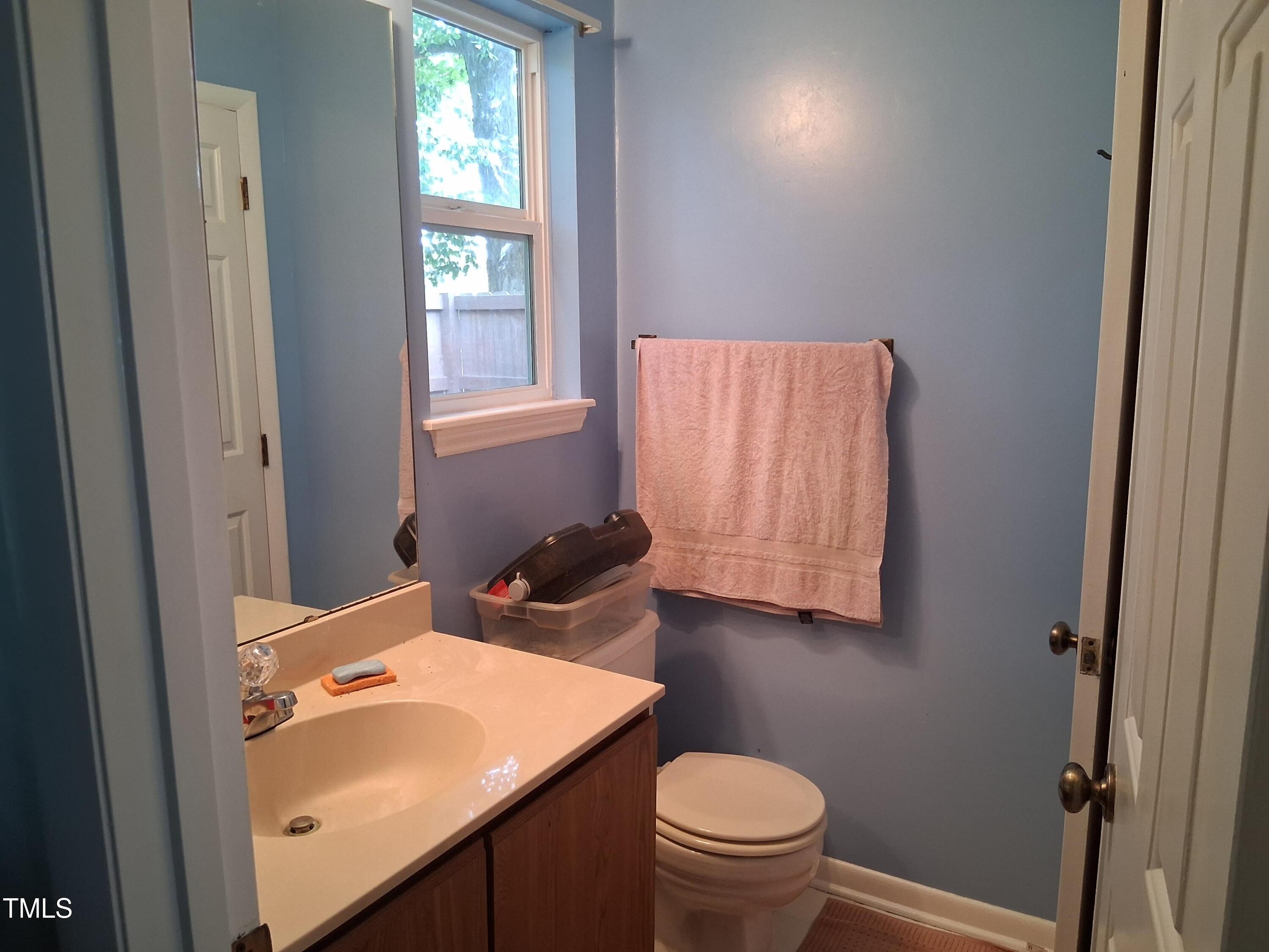6014 Farm Gate Road Raleigh, NC 27606 - Photo 3 of 3 a bathroom with a sink toilet and window