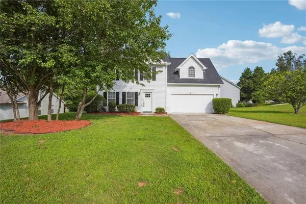 a front view of a house with yard and green space