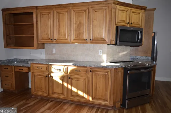 a kitchen with stainless steel appliances granite countertop a stove and a microwave