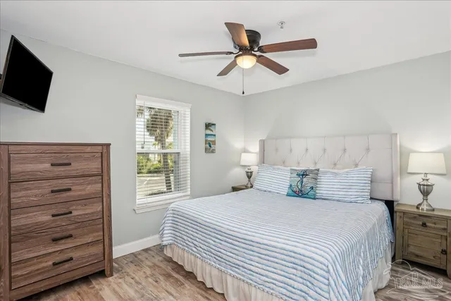 a bedroom with a large bed and a flat tv screen on dresser