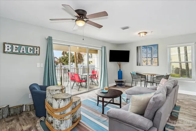 a living room with furniture a flat screen tv and a large window