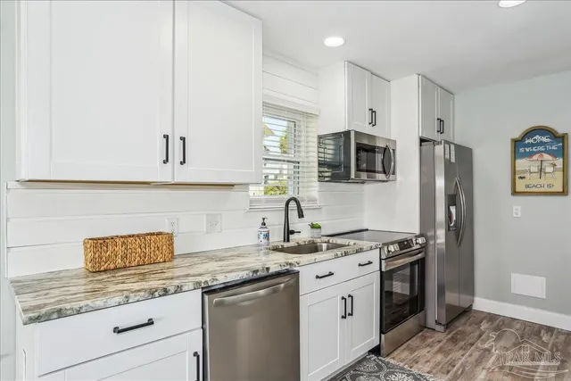 a kitchen with stainless steel appliances granite countertop a stove a sink and a refrigerator