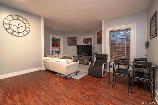 a living room with furniture a wooden floor and a flat screen tv