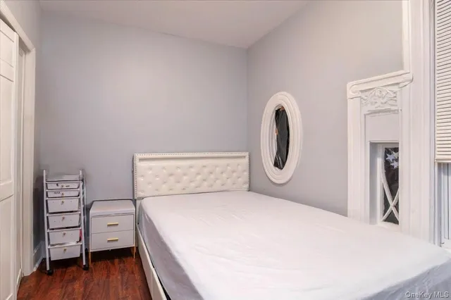 a bedroom with a bed and a large mirror next to a window