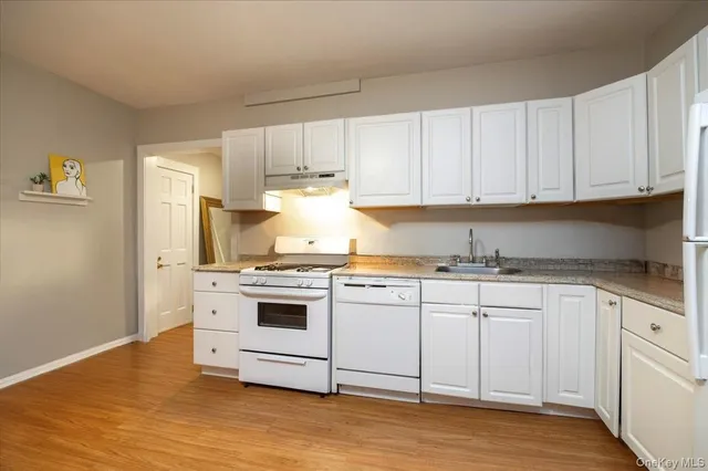 a living room with furniture and a refrigerator