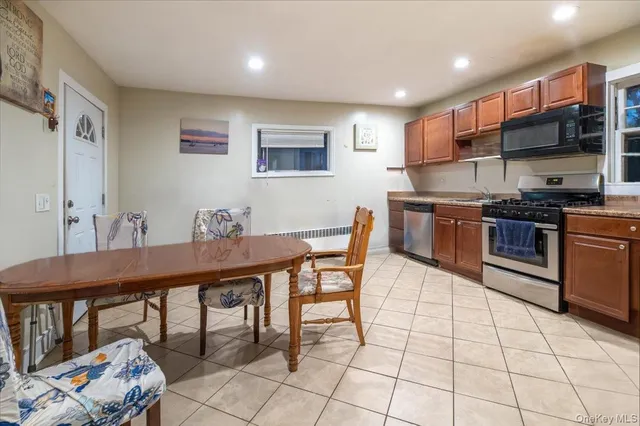 a kitchen with stainless steel appliances granite countertop a stove a sink a dining table and chairs