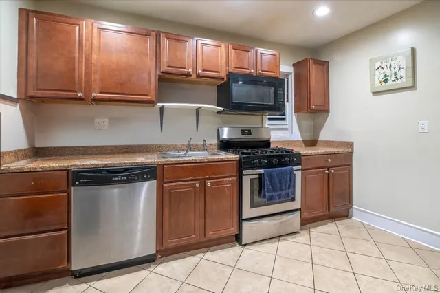a kitchen with stainless steel appliances granite countertop a stove a sink and a microwave