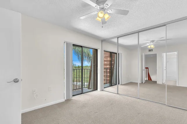 an empty room with closet and a chandelier fan