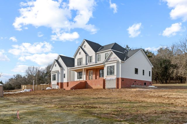 a view of a big house with a big yard and large tree
