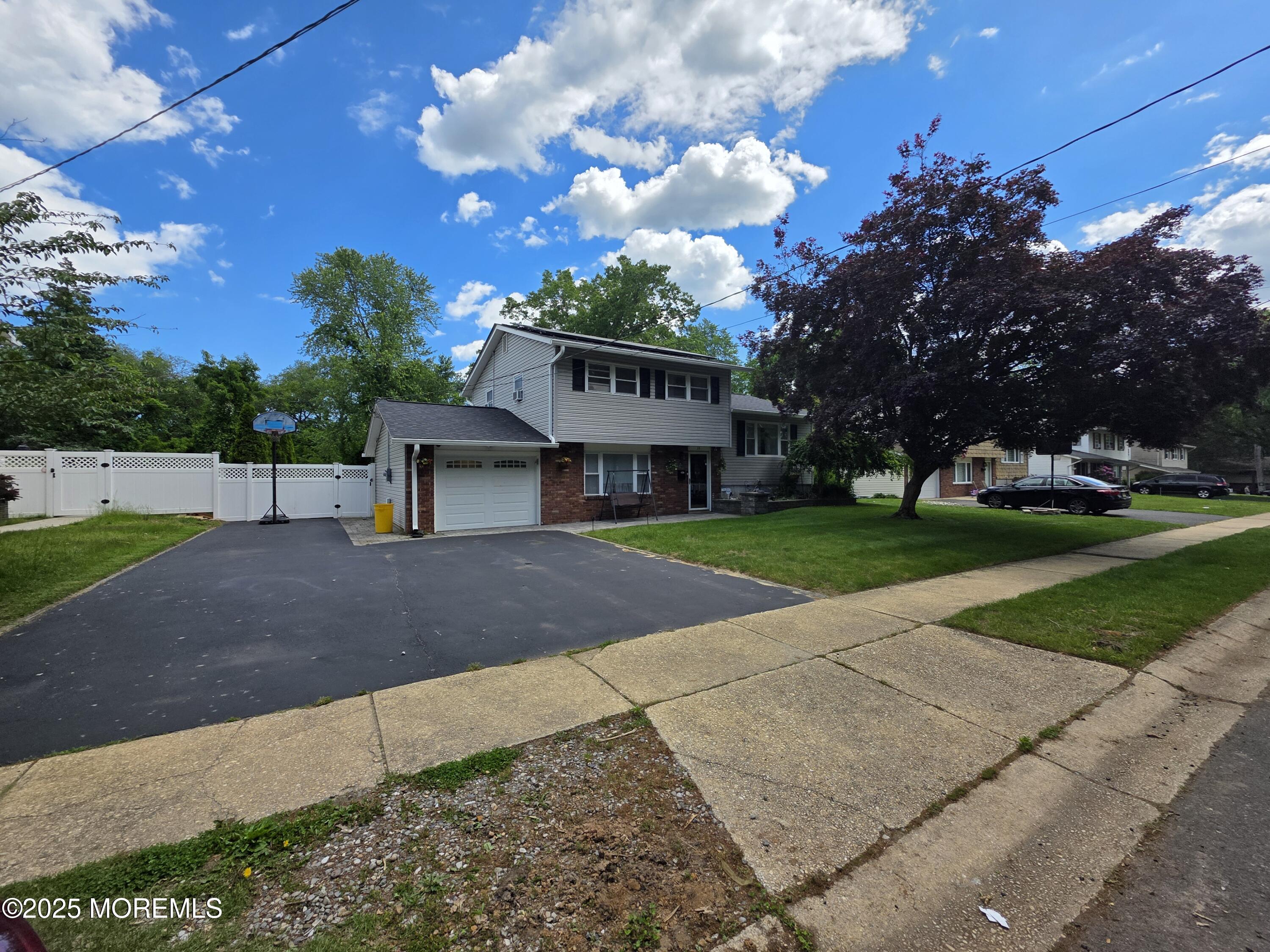 a view of a house with a big yard plants and large trees