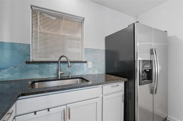 a kitchen with stainless steel appliances granite countertop a refrigerator and a sink