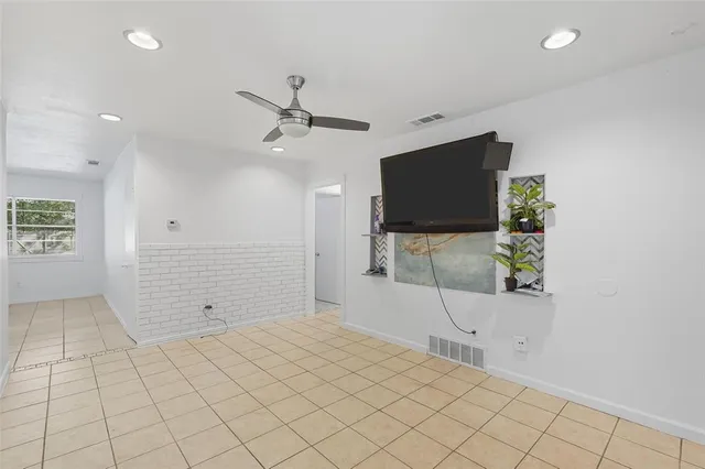 a view of room with wooden floor and flat screen tv