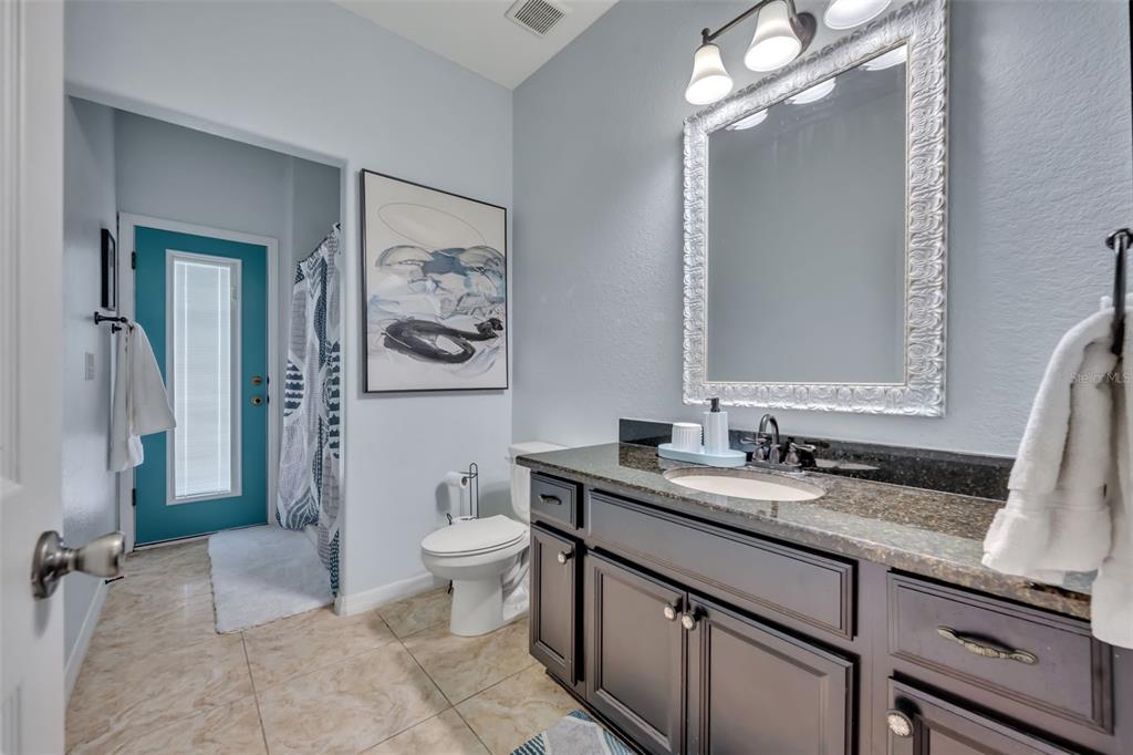 4946 Northeast 124th Road Oxford, FL 34484 - Photo 39 of 69 a bathroom with a sink a toilet a mirror and shower