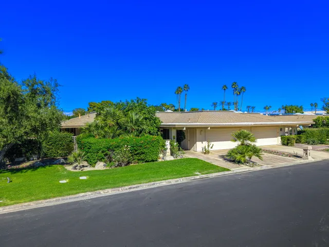 a front view of a house with a yard and a garage