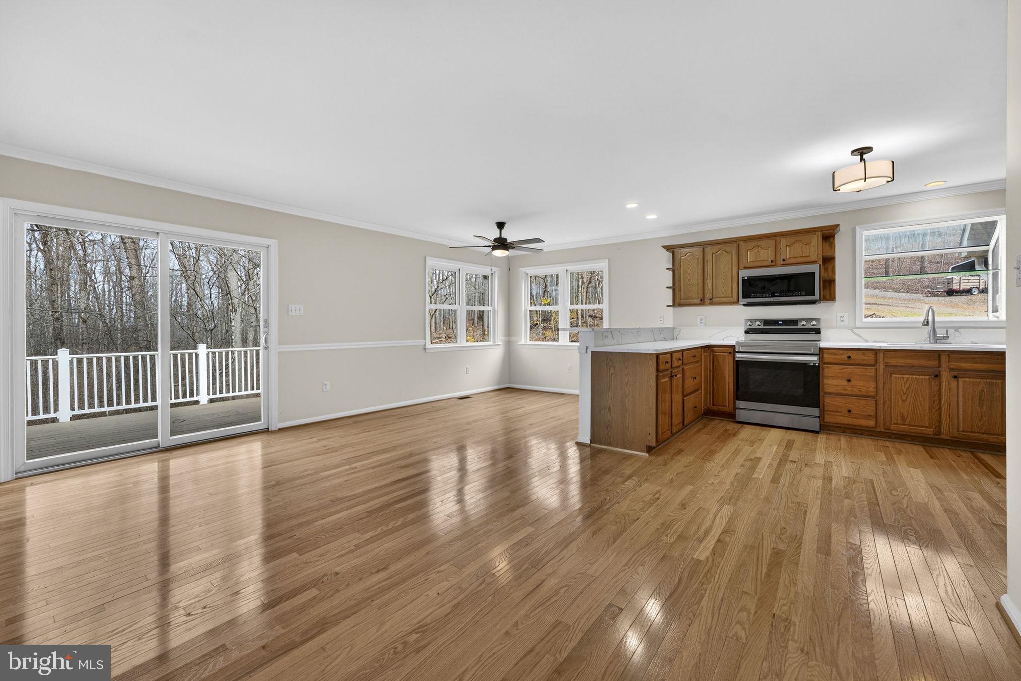 584 South Poes Road Amissville, VA 20106 - Photo 33 of 82 a living room with stainless steel appliances granite countertop a refrigerator a stove top oven a sink dishwasher and wooden cabinets with wooden floor