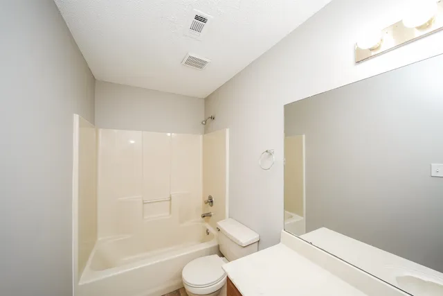a bathroom with a toilet a sink and shower