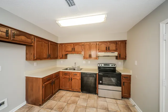 a kitchen with a stove sink and cabinets