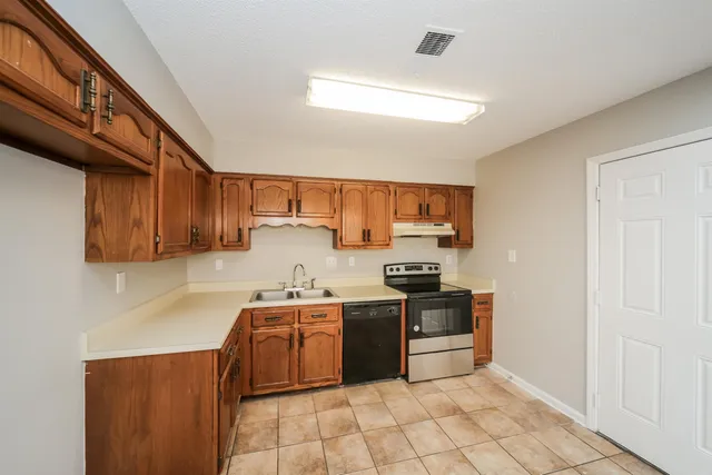 a kitchen with stainless steel appliances a sink stove and cabinets