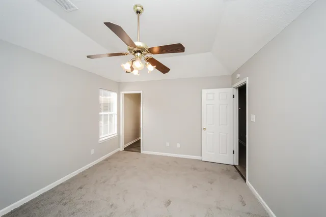 an empty room with fan and windows