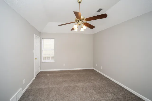 an empty room with a window and a fan