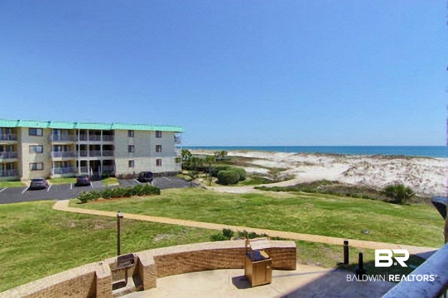 375 Plantation Road, Unit 5105 Gulf Shores, AL 36542 - Photo 9 of 9 Expansive outdoor space featuring a concrete patio with a curved stone-finish wall, built-in grill, and landscaped green areas