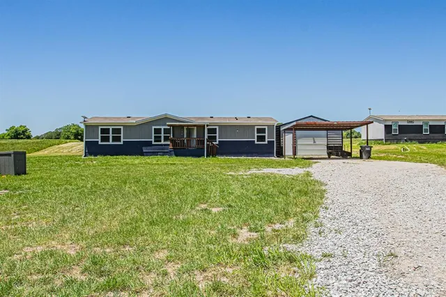 a view of a house with a big yard and large trees