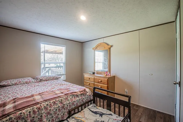 a bedroom with a bed a table and windows