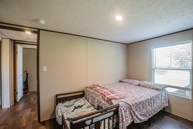 a bedroom with a bed and wooden floor