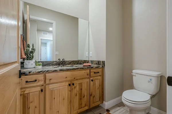 a bathroom with a granite countertop sink and a mirror