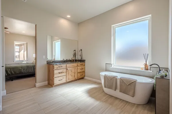 a view of an empty room with a window and a kitchen