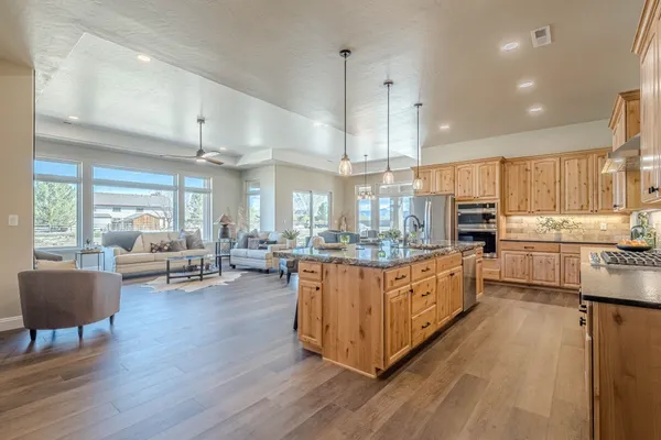 a large kitchen with kitchen island granite countertop a large center island attached withe living room