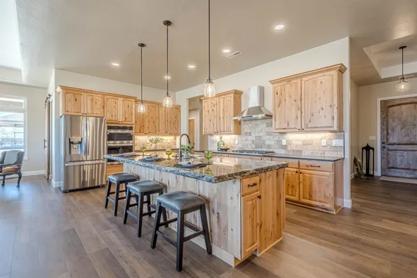 a kitchen with kitchen island granite countertop a stove and a sink