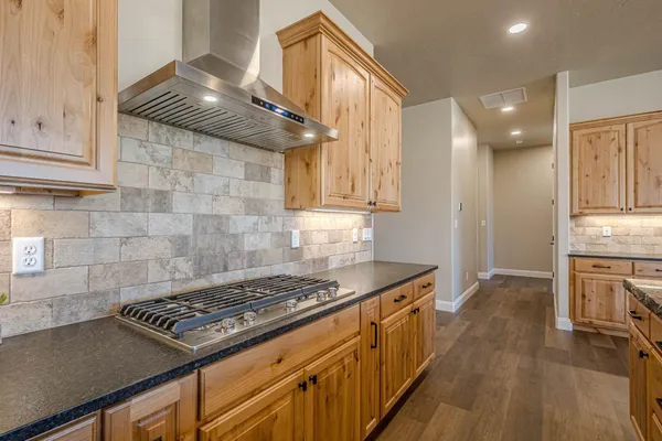 a living room with lots of furniture kitchen view and a chandelier