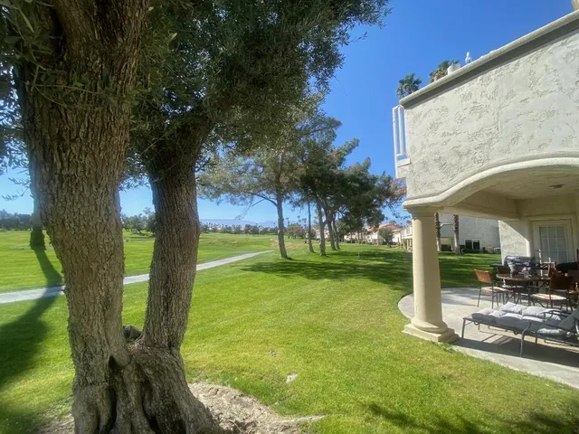 a view of a house with backyard and sitting area