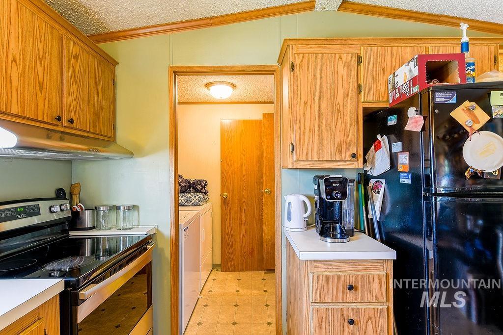 609 North Almon Street, Unit 3022 Moscow, ID 83843 - Photo 12 of 26 Kitchen featuring stainless steel range with electric stovetop, freestanding refrigerator, light flooring, light countertops, and washing machine and dryer