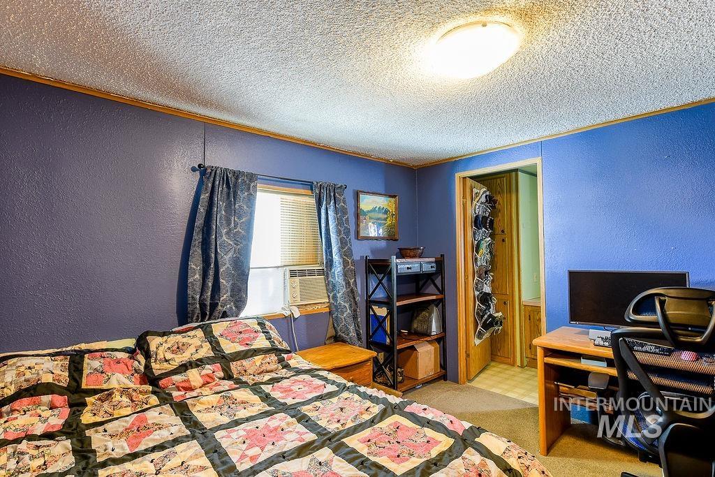 609 North Almon Street, Unit 3022 Moscow, ID 83843 - Photo 14 of 26 Bedroom with a textured wall, a textured ceiling, light colored carpet, and cooling unit