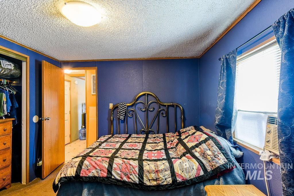 609 North Almon Street, Unit 3022 Moscow, ID 83843 - Photo 15 of 26 Bedroom with light carpet, a closet, a textured ceiling, a textured wall, and cooling unit