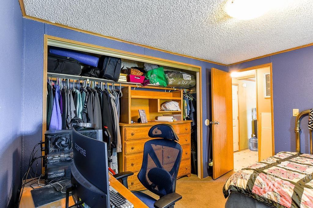609 North Almon Street, Unit 3022 Moscow, ID 83843 - Photo 16 of 26 Bedroom featuring light colored carpet, a closet, a textured wall, a textured ceiling, and a desk