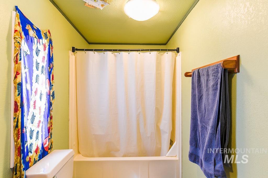 609 North Almon Street, Unit 3022 Moscow, ID 83843 - Photo 18 of 26 Bathroom featuring shower / bathtub combination with curtain, a textured ceiling, a textured wall, and ornamental molding