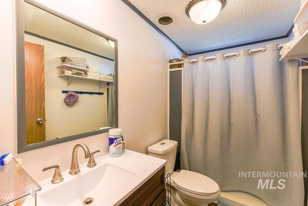 609 North Almon Street, Unit 3022 Moscow, ID 83843 - Photo 19 of 26 Full bath with vanity, a textured ceiling, and a shower with curtain