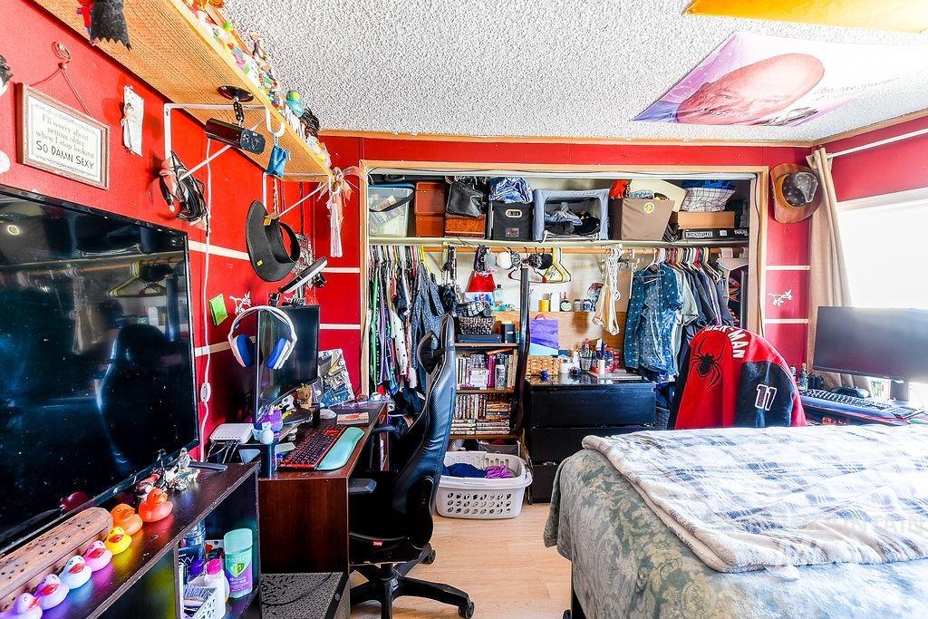 609 North Almon Street, Unit 3022 Moscow, ID 83843 - Photo 21 of 26 Bedroom featuring an office area, light wood-style flooring, a textured ceiling, and a closet