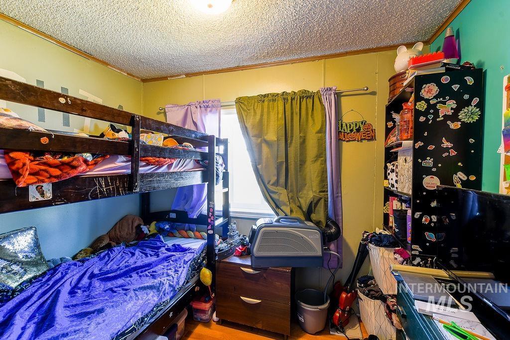 609 North Almon Street, Unit 3022 Moscow, ID 83843 - Photo 23 of 26 Bedroom featuring ornamental molding, a textured ceiling, and light wood-style floors