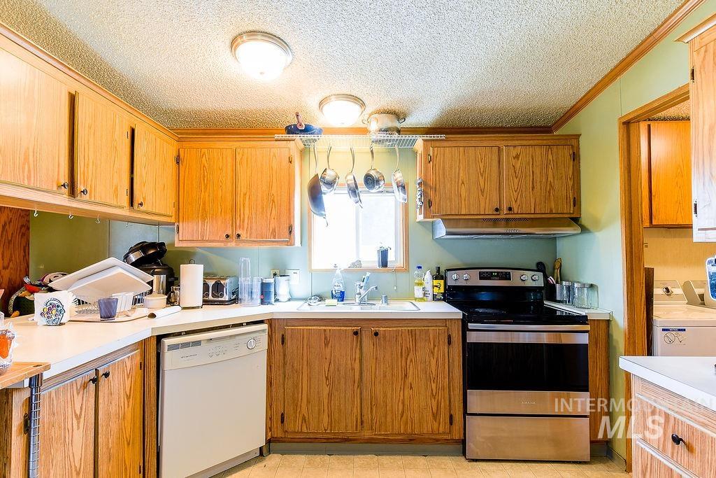 609 North Almon Street, Unit 3022 Moscow, ID 83843 - Photo 9 of 26 Kitchen with electric range, white dishwasher, light countertops, a textured ceiling, and wood finish cabinetry