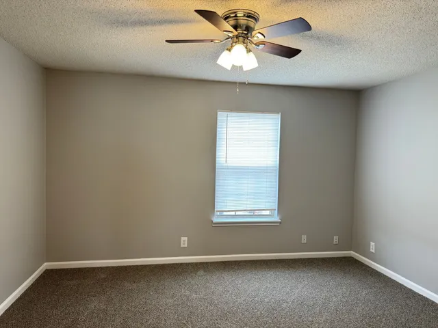 an empty room with a fan and a fan