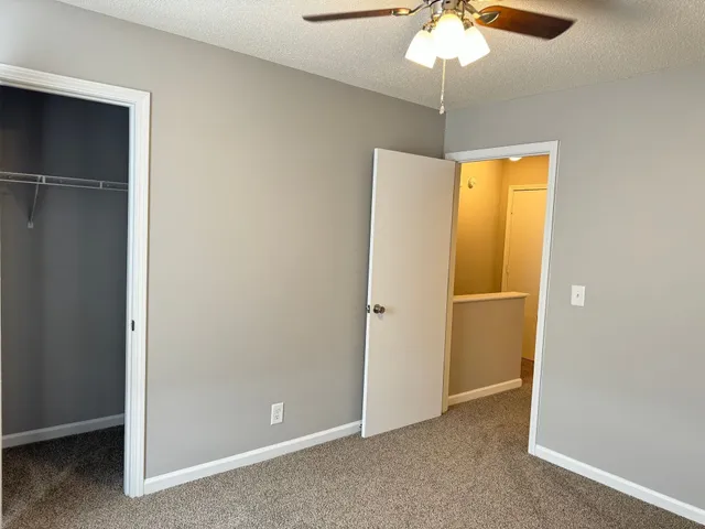 an empty room with a window and a chandelier fan