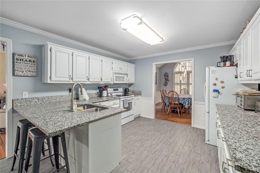 4609 Hunters Court Gainesville, GA 30507 - Photo 14 of 46 a kitchen with stainless steel appliances granite countertop a lot of counter space and wooden floor