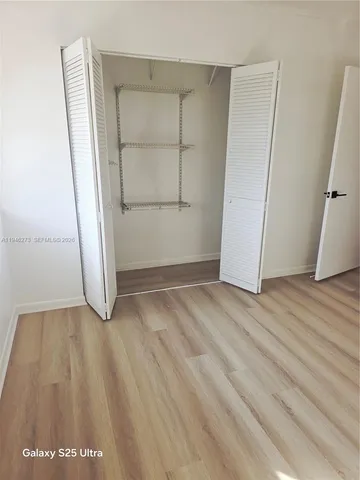 an empty room with wooden floor and closet